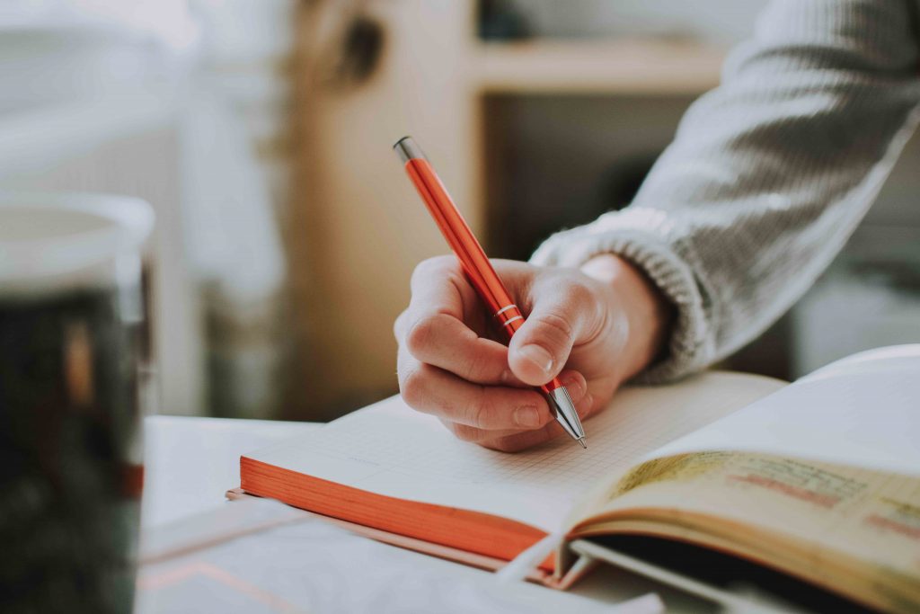 Student taking notes on research project